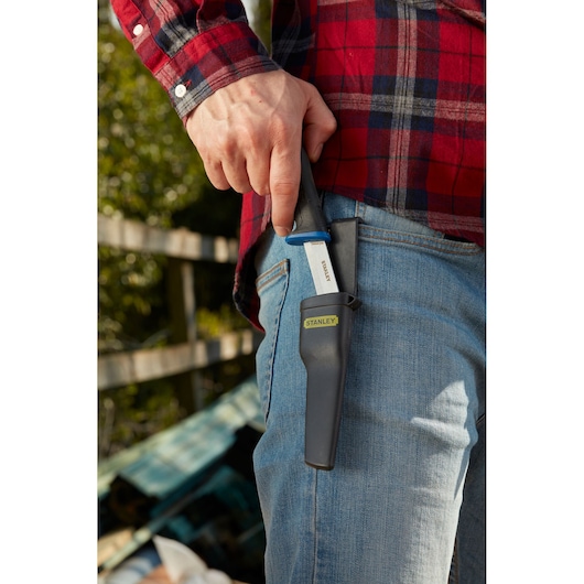 Photo of STANLEY 0-10-232 utility knife with black handle and sheath, clipped to jeans pocket outdoors.