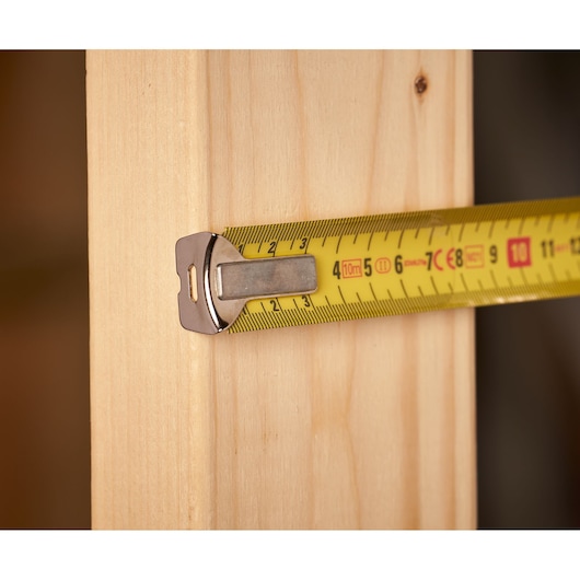 STANLEY 0-33-532 tape measure shown measuring a wooden beam, close-up side angle.