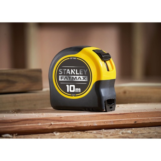 STANLEY 0-33-811 FATMAX 10m tape measure on wood, side angle photography.