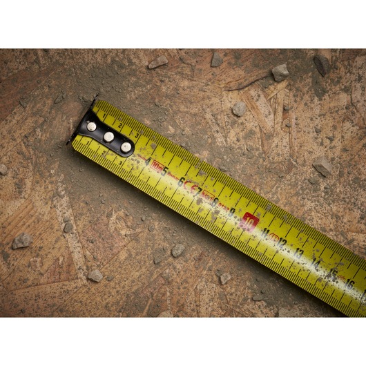 STANLEY 0-33-811 tape measure photography, yellow blade on dusty construction surface.
