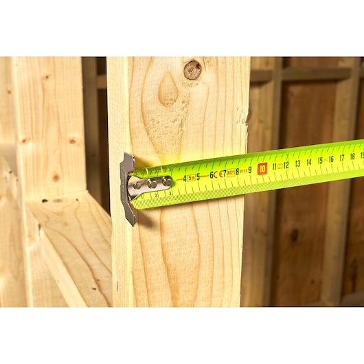 STANLEY 0-33-887 tape measure measuring wooden beams, photography showing close-up side view.
