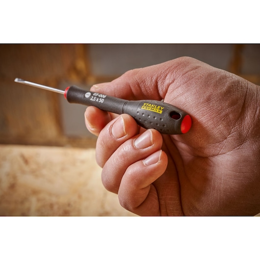 Stanley 0-65-006 precision screwdriver with black and red handle held in a hand, photography close-up.