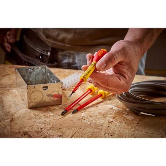 STANLEY 0-65-410 insulated screwdriver set with red and yellow handles on a workbench with electrical materials.