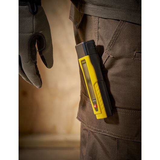 STANLEY 0-77-030 laser distance measurer in yellow and black clipped to brown work pants, side view.
