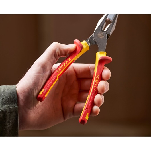 STANLEY 0-84-001 insulated pliers with red and yellow handles held in hand, close-up photo.