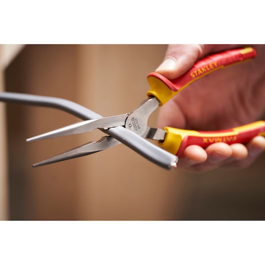 STANLEY 0-84-007 insulated long nose pliers cutting gray wire, close-up of tool in use.