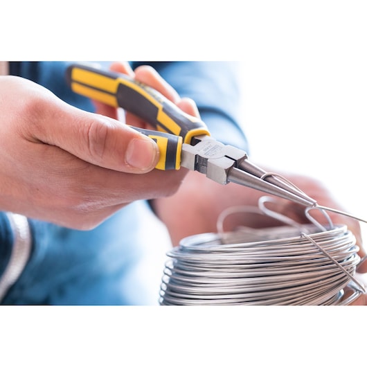 STANLEY 0-84-496 long nose pliers with yellow and black handle bending metal wire, close-up photography.