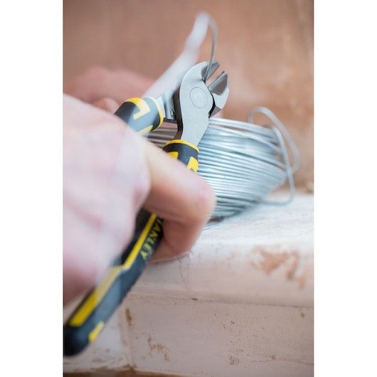 STANLEY 0-89-859 diagonal cutting pliers close-up cutting wire, black and yellow ergonomic handle.