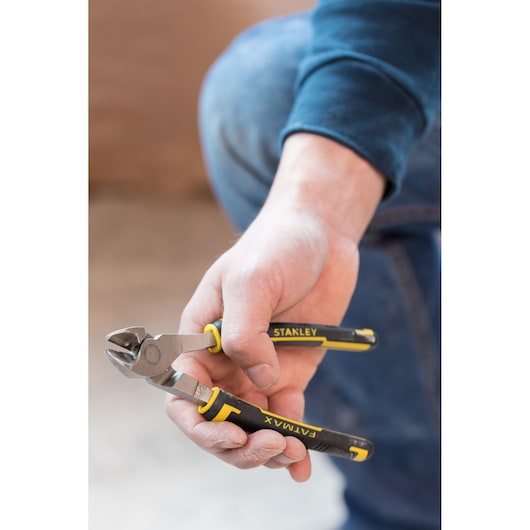 STANLEY 0-89-860 diagonal cutting pliers with black and yellow handles held in hand, close-up photo.