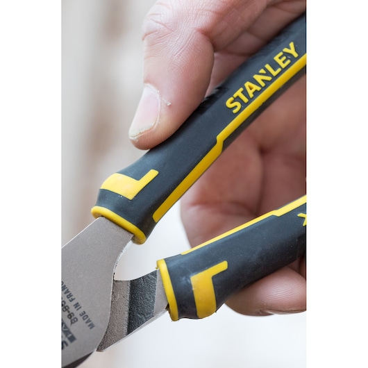 Close-up photo of STANLEY 0-89-868 pliers with black and yellow handle, gripped by a hand.