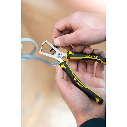 STANLEY 0-89-873 black and yellow pliers with FATMAX grip held in hand, close-up view.