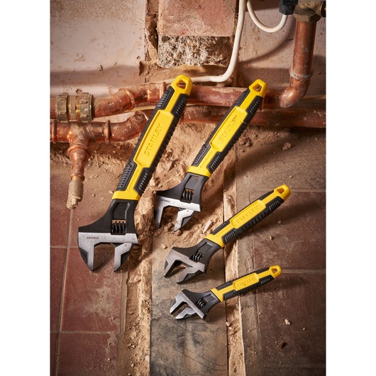 STANLEY 0-90-950 adjustable wrench set with yellow handles shown on a construction site floor.