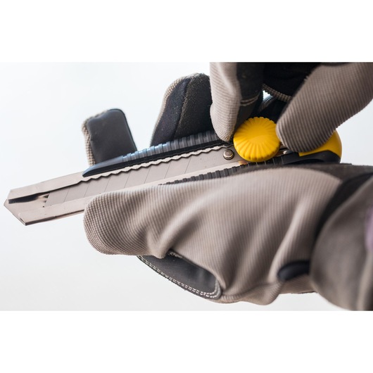 STANLEY 1-10-418 utility knife with yellow wheel held by gloved hands, close-up view.