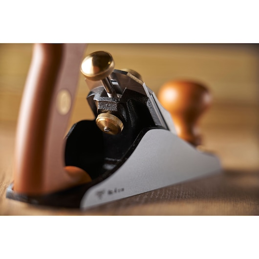 STANLEY 1-12-136 hand plane with wood and brass details, angled close-up on smooth bench.