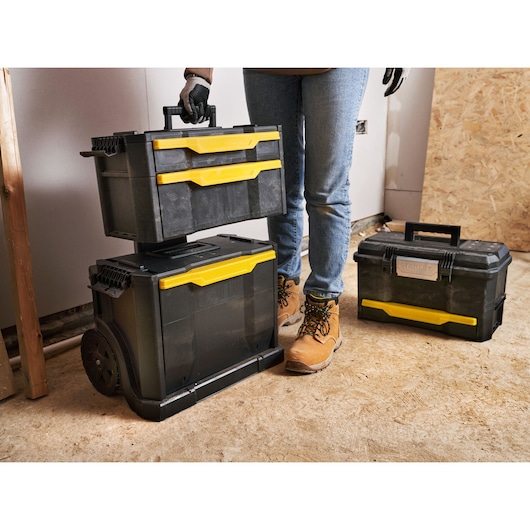STANLEY 1-79-206 toolbox set, black with yellow handles, shown in a workshop setting, photo at front angle.