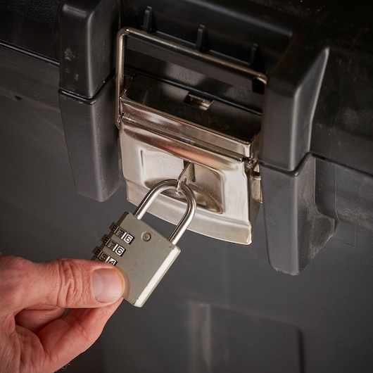 STANLEY 1-92-978 lockable toolbox close-up with combination padlock on latch and hand holding lock.