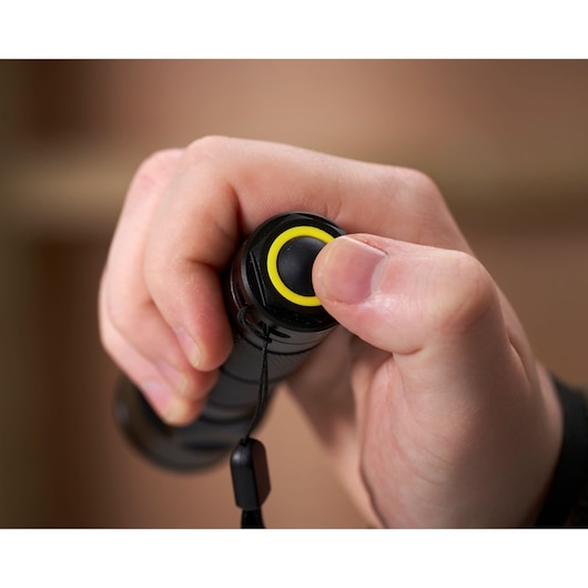 Close-up photo of a hand pressing the yellow-ringed button on STANLEY 1-95-152 photography tool handle.