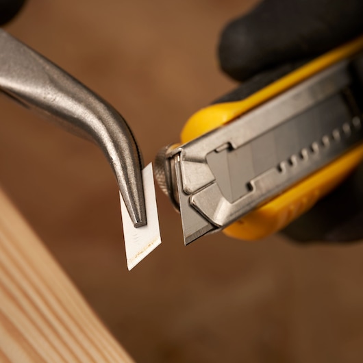 STANLEY 2-11-301 utility knife blade close-up with pliers removing segmented blade.