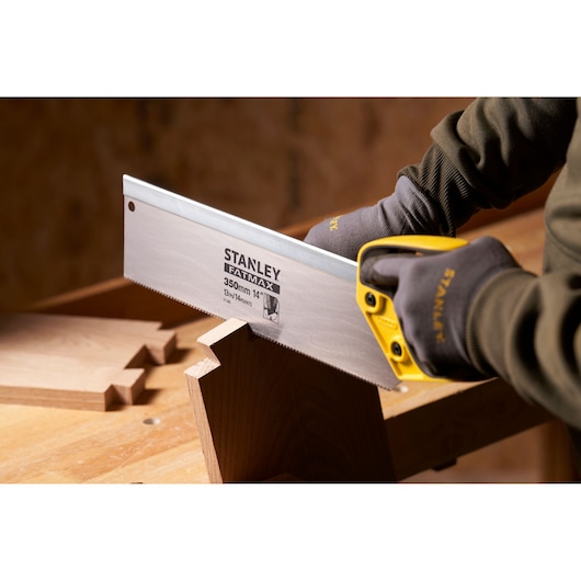 Photo of STANLEY 2-17-202 hand saw with yellow handle cutting wood, close-up in workshop setting.