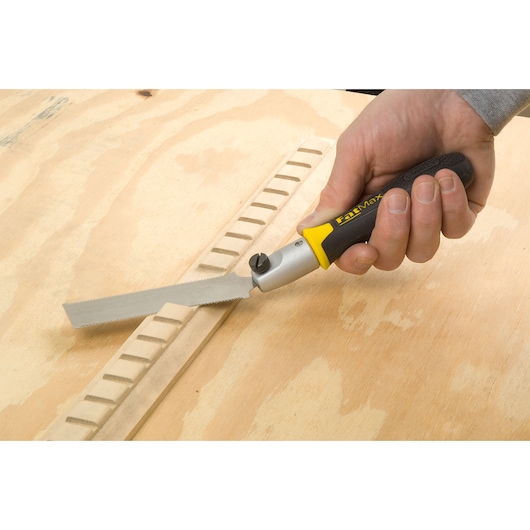STANLEY 3-20-331 folding saw with black and yellow handle used on wood surface, close-up photo.