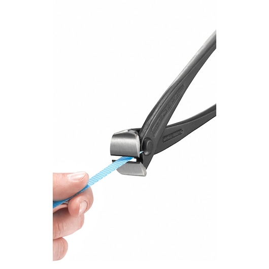 STANLEY 4-95-098 end cutting nippers cutting blue strap, close-up on tool and hand, white background.