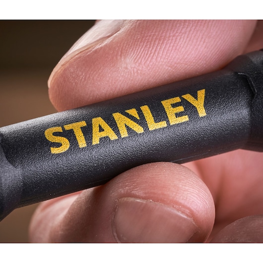 STANLEY 66-344M black tool handle with yellow logo held between fingers, close-up photo.