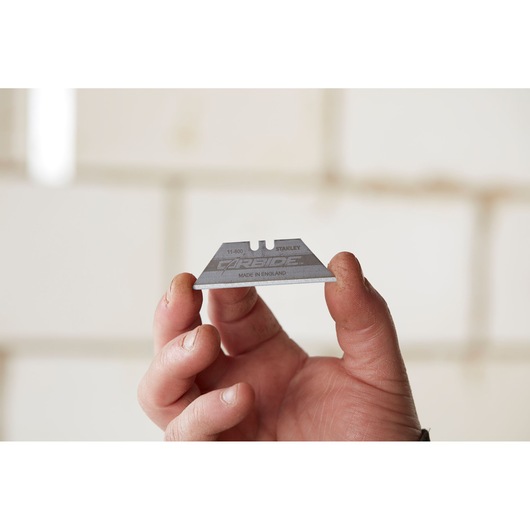 Photo of STANLEY 8-11-800 utility blade held between fingers, silver color, product name visible.