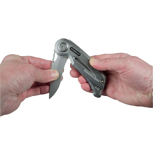 Photo of STANLEY 9-10-813 folding knife being opened by hand, close-up view.