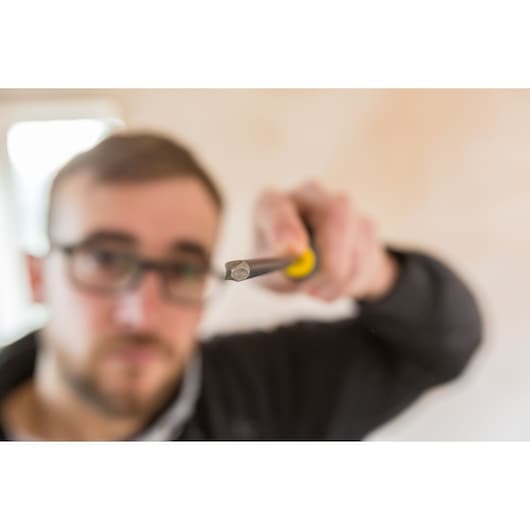 Photo of STANLEY FMHT0-62062 hex screwdriver held in hand, close-up with yellow and black handle.