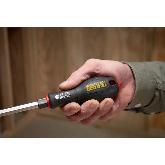 Stanley FMHT0-62621 slotted screwdriver with black and yellow handle, held in hand.