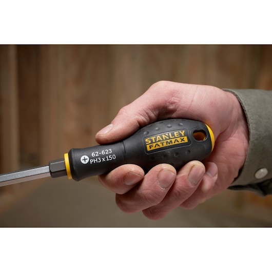 STANLEY FMHT0-62623 screwdriver with black and yellow handle, FATMAX branding, shown held in a hand.