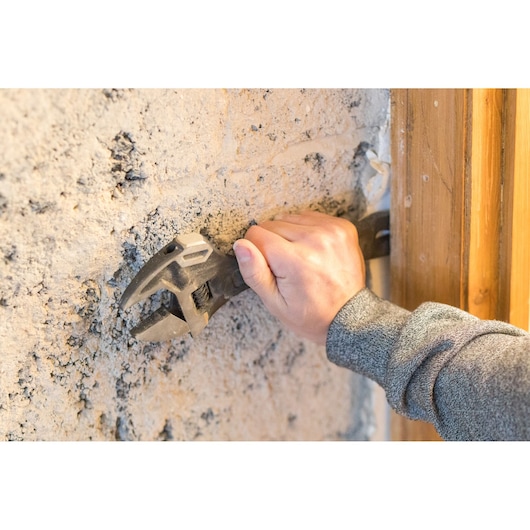 Photo of STANLEY FMHT0-75081 adjustable wrench held against a rough concrete wall.