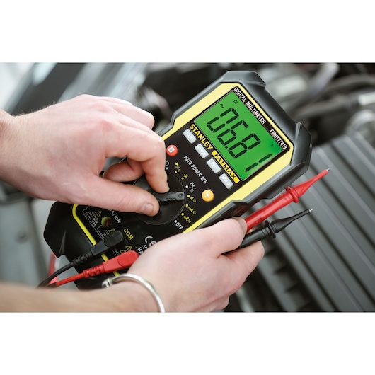 STANLEY FMHT0-77419 digital multimeter with large display in use, photographed close-up.