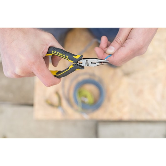 STANLEY FMHT0-80517 long nose pliers with yellow-black handle in use, gripping blue wire.