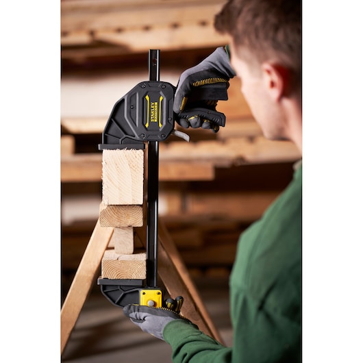 STANLEY FMHT0-83239 photography of quick grip clamp securing wooden blocks in workshop.