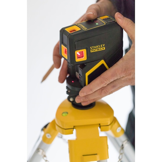 Stanley FMHT1-77413 laser level photography showing device on tripod with hands adjusting.
