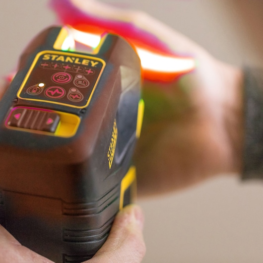STANLEY FMHT1-77414 handheld wall scanner with control panel, shown in use, close-up photography.