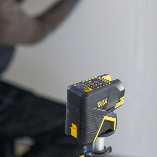 STANLEY FMHT1-77414 laser level in black and yellow on tripod, close-up, construction photography.