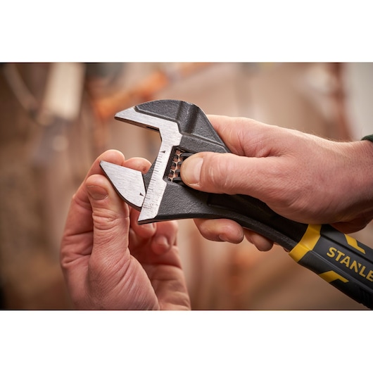 Photo of STANLEY FMHT13126-0 adjustable wrench with black and yellow handle being adjusted by hand.