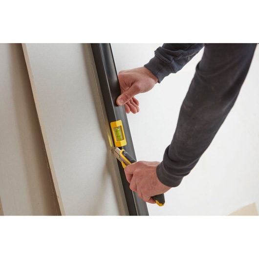 STANLEY FMHT42559-1 level tool used to align and cut drywall, close-up photography.