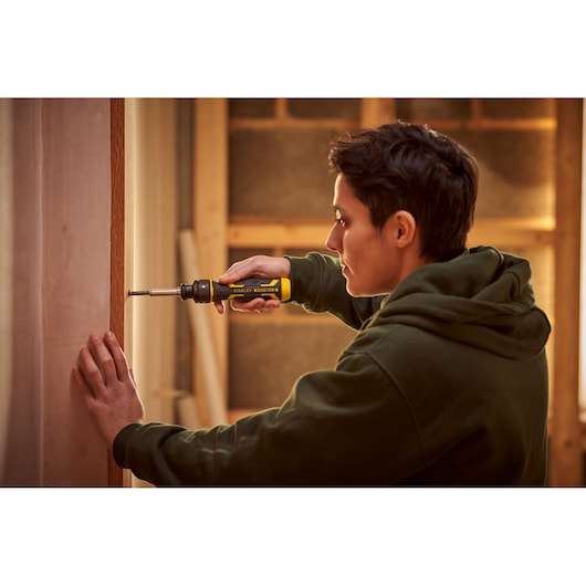 Person using STANLEY FMHT62692-0 screwdriver on door frame, product shown in use, indoor setting.