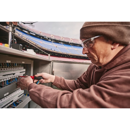 STANLEY FMHT66426-0 insulated screwdriver in use on electrical panel in stadium setting.