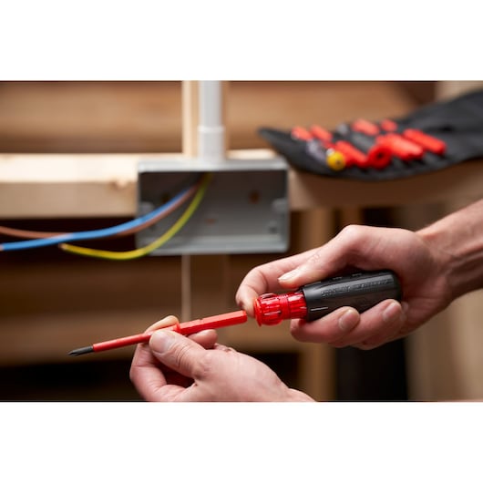 STANLEY FMHT66426-0 insulated screwdriver with interchangeable red bit, electrician usage in workshop.
