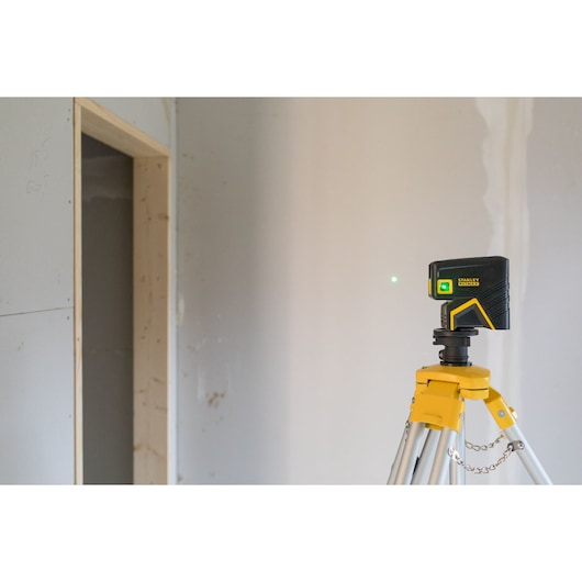 STANLEY FMHT77596-1 laser level on tripod in a room under construction, side angle photo.