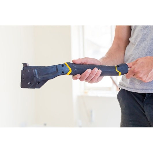 STANLEY FMHT81394-9 heavy-duty stapler gun held in hand, angled view, black and yellow design.
