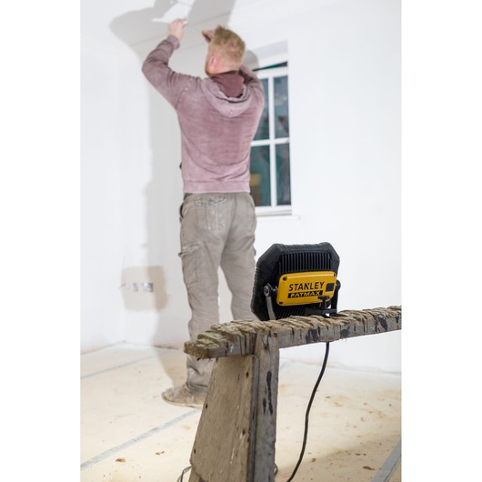 STANLEY FMHT81508-1 work light on bench in renovation scene with person painting wall.