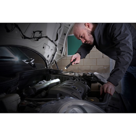 STANLEY FMHT81510-0 pen light in use inspecting car engine, automotive photography.