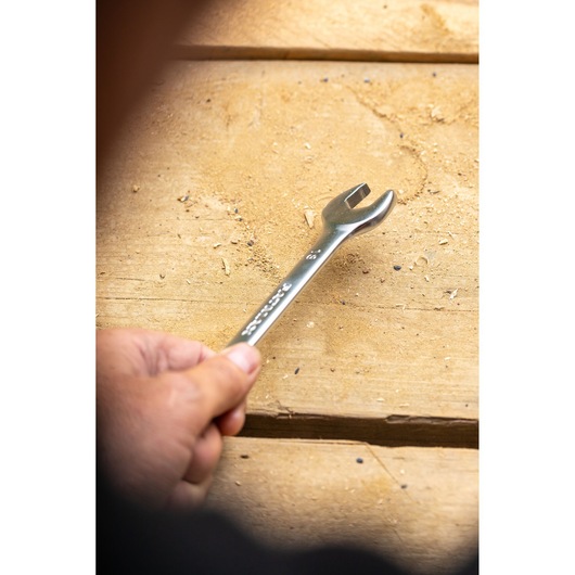 STANLEY FMMT13035-0 open-end wrench held on a wooden surface, silver metal finish.