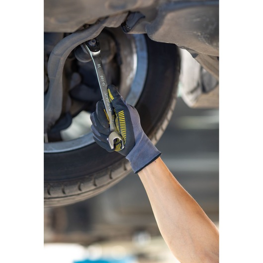 Photo of STANLEY FMMT13096-0 wrench being used to tighten a bolt under a car wheel by a gloved hand.