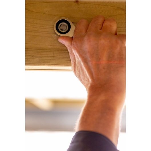 STANLEY FMMT13097-0 ratchet wrench in use tightening a bolt on wood, close-up photo.